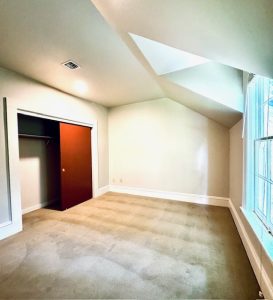 Bedroom with closet, window and skylight