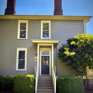 Exterior of 1451 entry. Small awning and window on first floor, two windows on second floor.